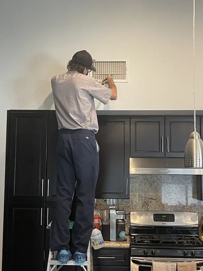 Technician inspecting an air vent during HVAC service in Brunswick